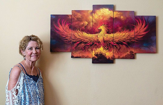 Claremont resident Terry Wilhelm stands beside a phoenix rising